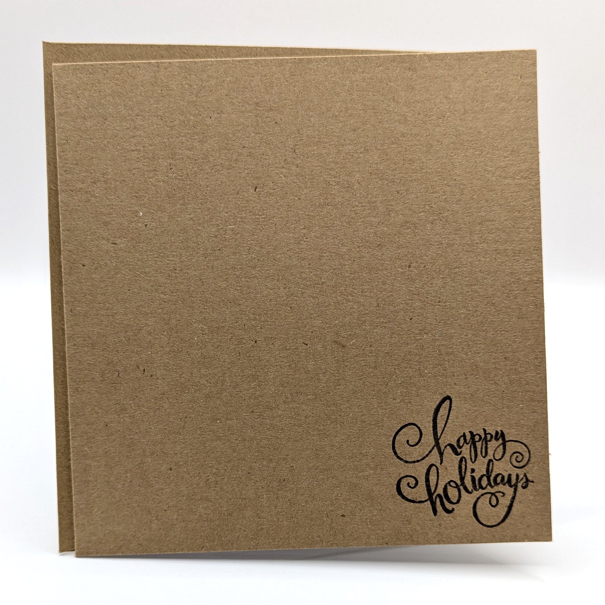 happy holidays stamped in black ink onto a kraft card, comes with envelope