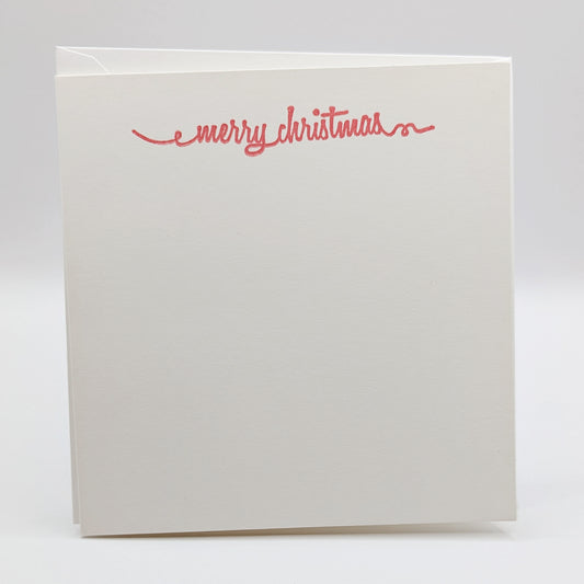 merry Christmas in a script font, stamped in red ink onto a white card comes with matching envelope
